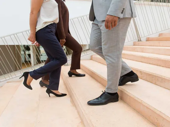 Three people walking up down stairs