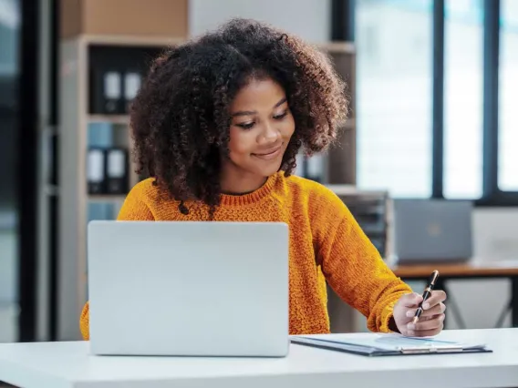 Woman sitting desk writing paper