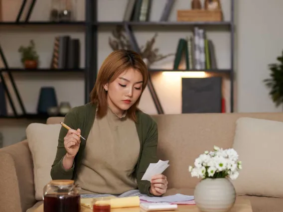 Woman viewing paper sitting living room