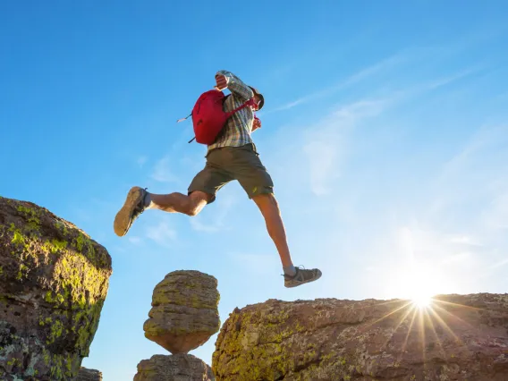 Man jumping over large rocks