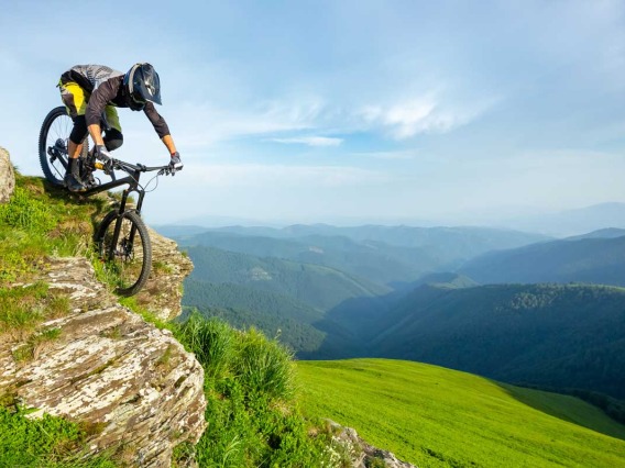 Biker riding down green mountain