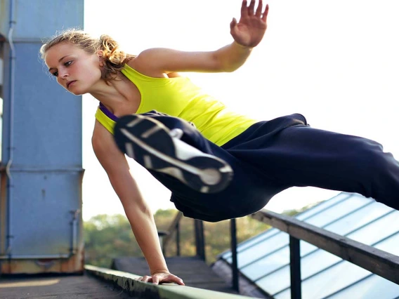 Woman jumping over hand rail