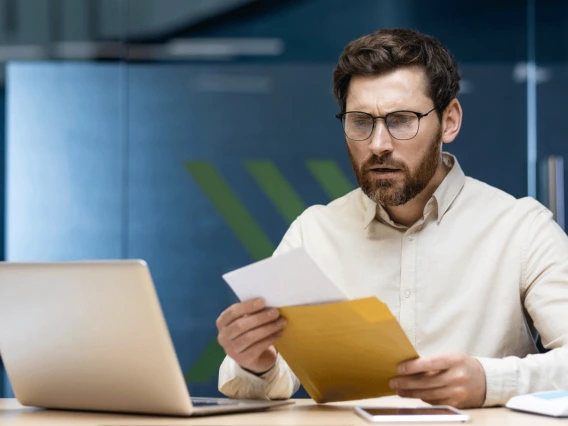 Man reading papers screen office