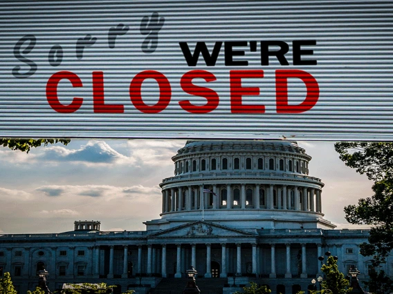 Sorry we're closed sign on window with U.S. capitol in the background
