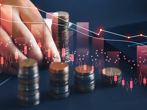 Businessman moving coins with downward sloping lines